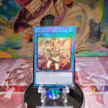 A Prismatic Collector's Rare "Aussa the Earth Charmer, Immovable" card from the Yugioh Set: Quarter Century Stampede (RA04).