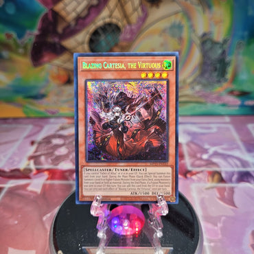 A Prismatic Secret Rare "Blazing Cartesia, the Virtuous" card from the Yugioh Dueling Heroes Mega-Tin Mega Pack.