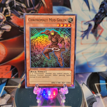 A Super Rare "Chronomaly Mud Golem" card from the Yugioh Set: Number Hunters.