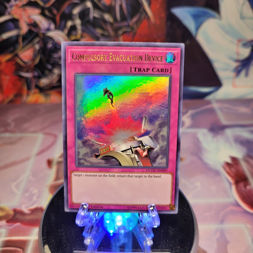 An Ultra Rare "Compulsory Evacuation Device" card from the Yugioh Set: Duel Overload (DUOV).