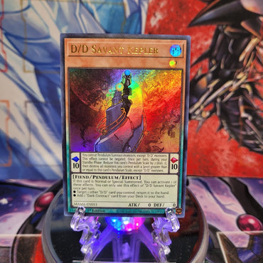 An Ultra Rare "D/D Savant Kepler" card from the Yugioh Set: Magnificent Mavens (MAMA).