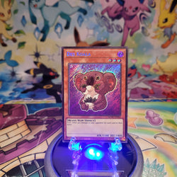 A Secret Rare "Des Koala" Chibi Art card from the Yugioh Set: Maze of Muertos (MZMU).