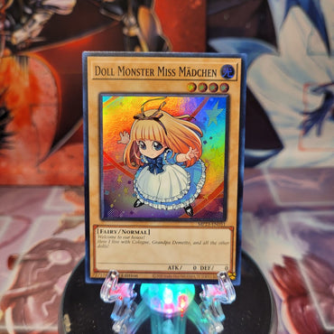 A Super Rare "Doll Monster Miss Madchen" card from the Yugioh 25th Anniversary Tin: Dueling Heroes set.