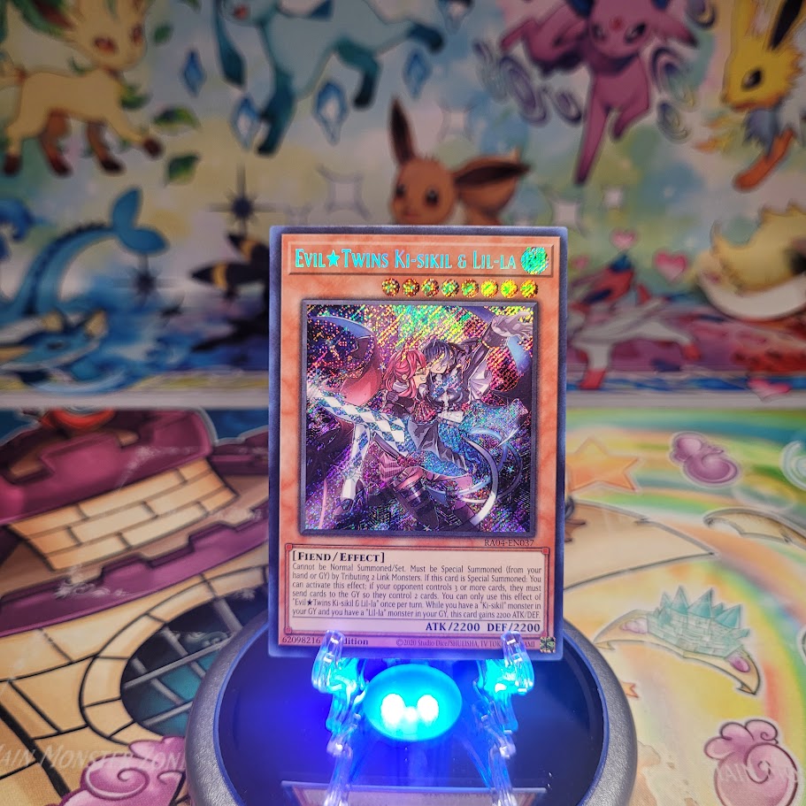 A Secret Rare "Evil Twins Ki-sikil & Lil-la" card from the Yugioh Set: Quarter Century Stampede (RA04).