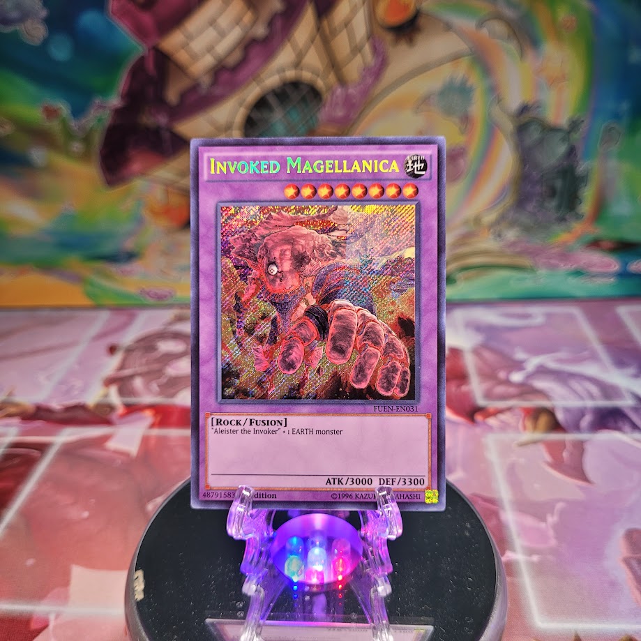 A Secret Rare "Invoked Magellanica" card from the Yugioh Set: Fusion Enforcers (FUEN).