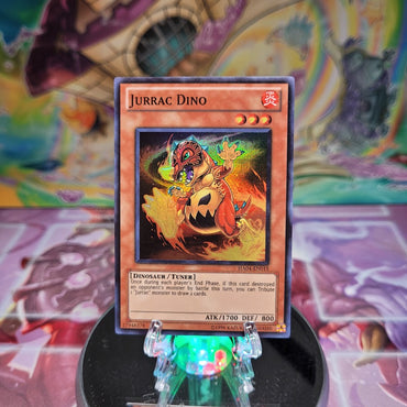 A Super Rare "Jurrac Dino" card from the Yugioh Set: Hidden Arsenal 4: Trishula's Triumph.