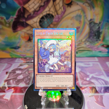 A Prismatic Collector's Rare "Live Twin Lil-La" card from the Yugioh Set: Quarter Century Stampede (RA04).