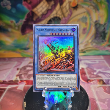 A 1st Edition Super Rare "Magikey Mechmortar - Garesglasser" card from the Yugioh Set: Dawn of Majesty.