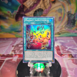 A Super Rare "Magnet Induction" card from the Yugioh Set: King's Court.