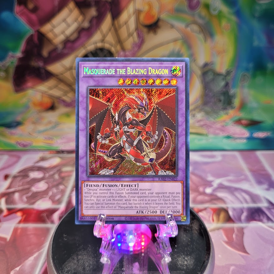 A Secret Rare "Masquerade the Blazing Dragon" card from the Yugioh Set: Rarity Collection 2 (RA02).