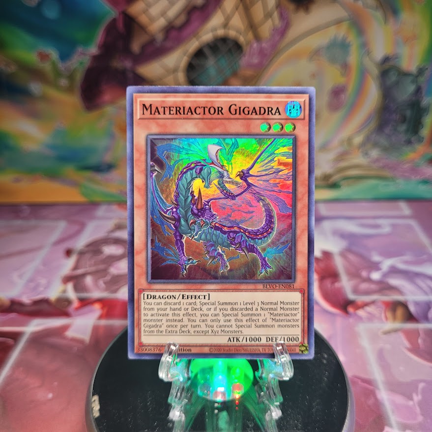 A Super Rare "Materiactor Gigadra" card from the Yugioh Set: Blazing Vortex.