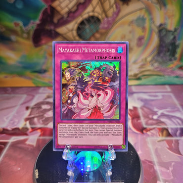 A 1st Edition Super Rare "Mayakashi Metamorphosis" card from the Yugioh Set: Hidden Summoners.