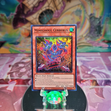 A Super Rare "Mimighoul Cerberus" card from the Yugioh Set: The Infinite Forbidden.