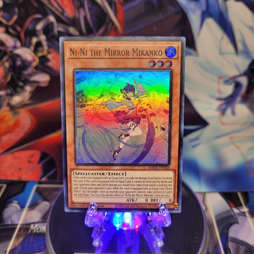 A Super Rare "Ni-Ni the Mirror Mikanko" card from the Yugioh Set: Amazing Defenders.