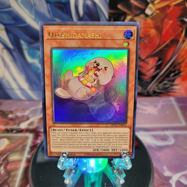 An Ultra Rare "Otoshidamashi" card from the Yugioh 2022 Tin of the Pharaoh's Gods Set.