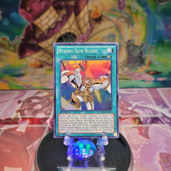 A Super Rare "Rising Sun Slash" card from the Yugioh Set: Dragons of Legend.