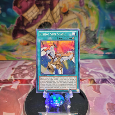 A Super Rare "Rising Sun Slash" card from the Yugioh Set: Dragons of Legend.