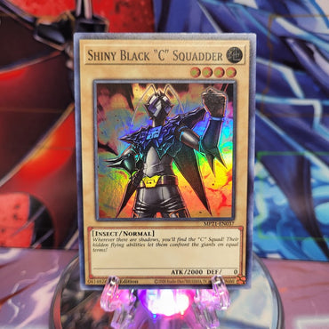  A Super Rare "Shiny Black "C" Squadder" card from the Yugioh 2021 Tin of Lost Memories.