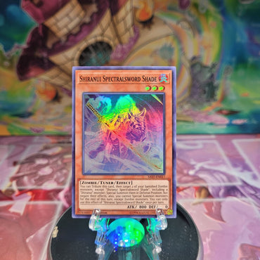 A Super Rare "Shiranui Spectralsword Shade" card from the Yugioh Set: Savage Strike.