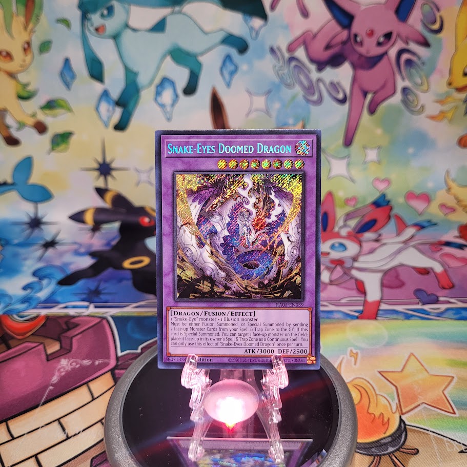A Secret Rare "Snake-Eyes Doomed Dragon" card from the Yugioh Set: Rarity Collection 5 (RA05).