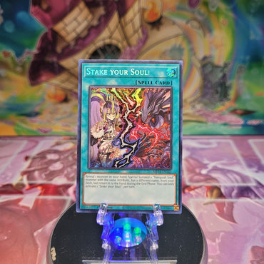 A Prismatic Secret Rare "Stake Your Soul" card from the Yugioh Set: 25th Anniversary Tin: Dueling Mirrors (MP24).