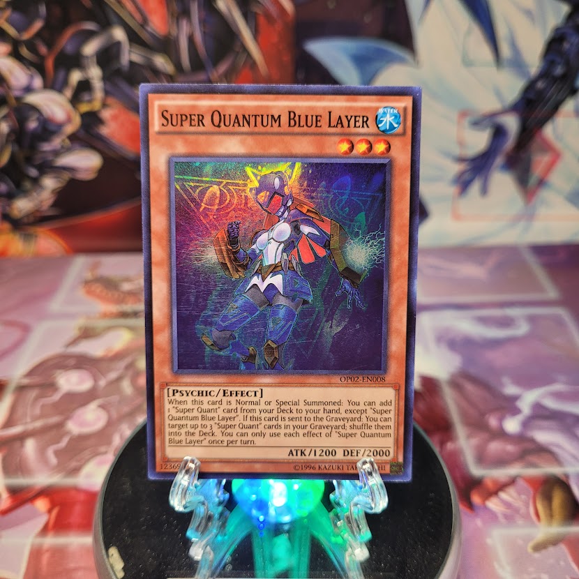 A Super Rare "Super Quantum Blue Layer" card from the Yugioh OTS Tournament Pack 2 set.