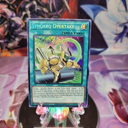  A Secret Rare "Synchro Overtake" card from the Yugioh Set: Dawn of Majesty (DAMA).
