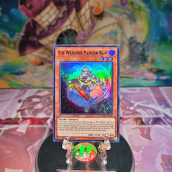 A Super Rare "The Weather Painter Rain" card from the Yugioh Set: Spirit Warriors.