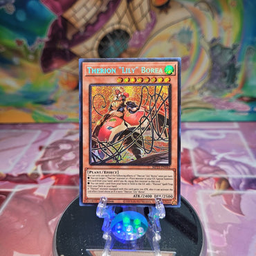 A Prismatic Secret Rare "Therion "Lily" Borea" card from the Yugioh Dueling Heroes Mega-Tin Mega Pack.